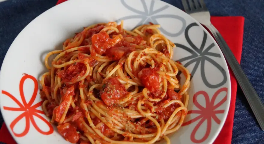 Pyszne spaghetti napoli przepis na talerzu, z sosem pomidorowym i ziołami. Idealne danie dla miłośników włoskiej kuchni.