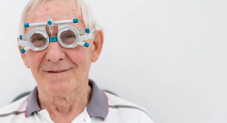 Anziano con occhiali da prova per esame della vista, controlla la vista per prevenire l'invecchiamento precoce della retina.