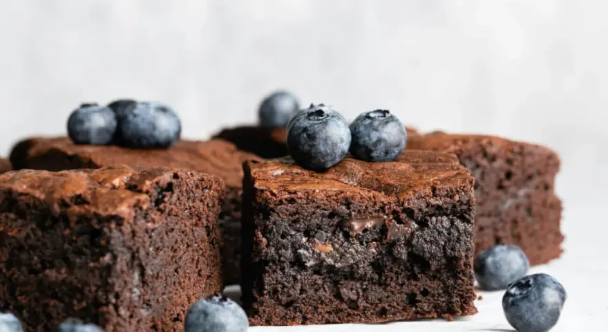 Keto brownie z mascarpone, udekorowane świeżymi borówkami. Idealne na deser bez wyrzutów sumienia.