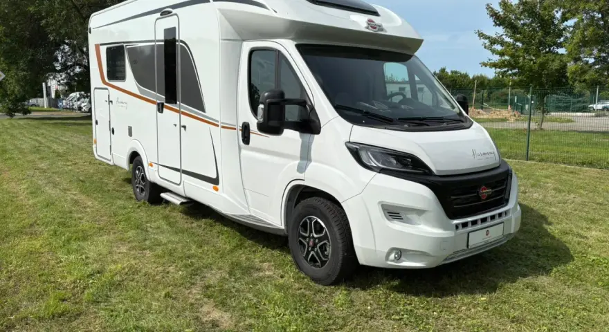 Biały kamper Burstner Lyseo Harmony Line stoi na zielonej trawie.