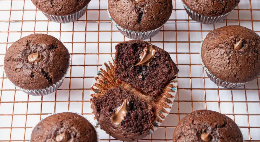 Plusieurs muffins au chocolat, dont un ouvert révélant une généreuse garniture de nutella.