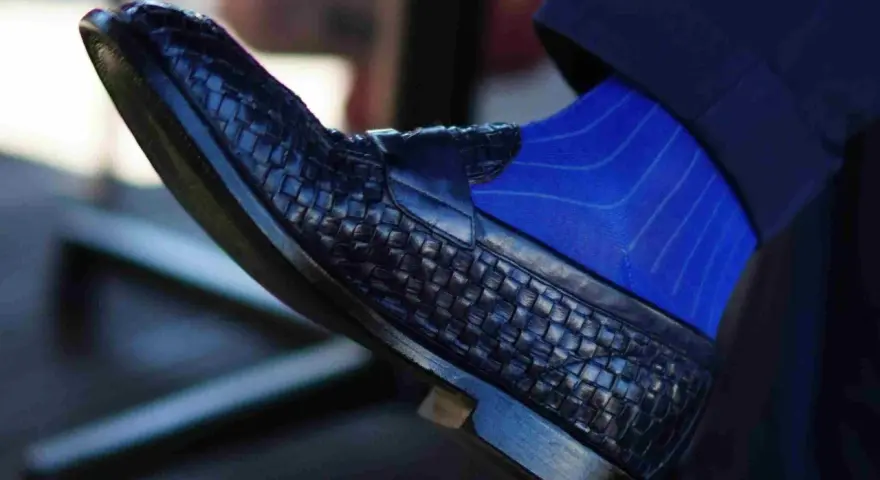 Scarpe blu intrecciate con calzini blu a righe: un abbinamento elegante per un look sofisticato.