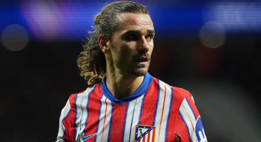 Grizman w koszulce Atletico Madryt, z charakterystyczną fryzurą, skupiony na boisku.