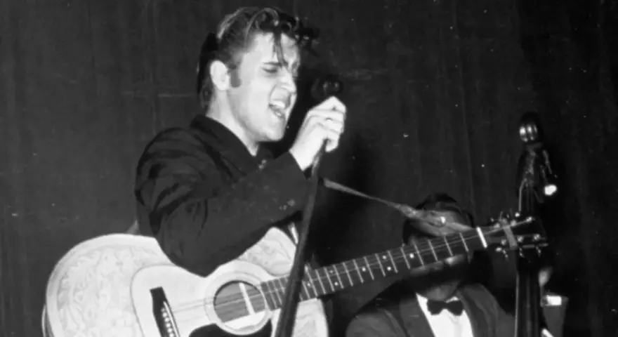 Elvis Presley singt mit Leidenschaft und spielt Gitarre. Ein historischer Moment, vielleicht sein erster Song.