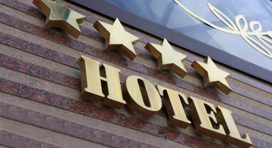 Złote gwiazdki nad napisem HOTEL. To one decydują, kto nadaje gwiazdki hotelom, wskazując na jego standard.