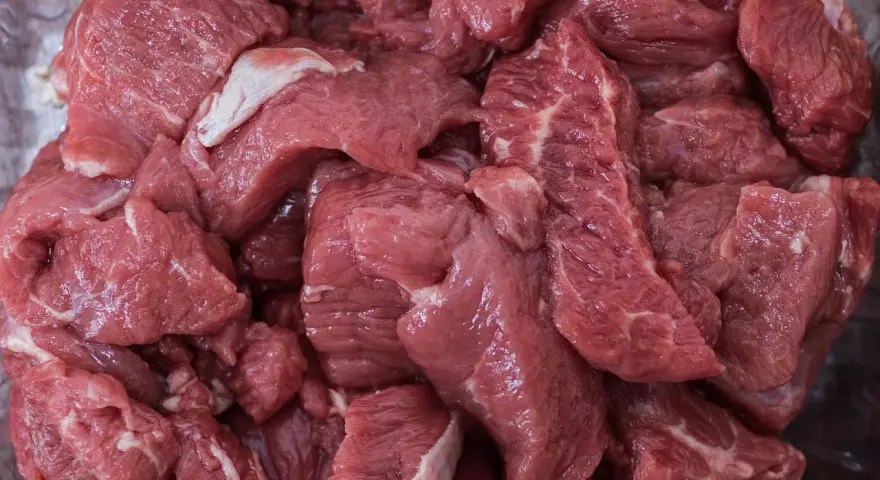 Gros morceaux de viande rouge crue, prêts pour une ration barf chien. Une alimentation naturelle pour votre compagnon.