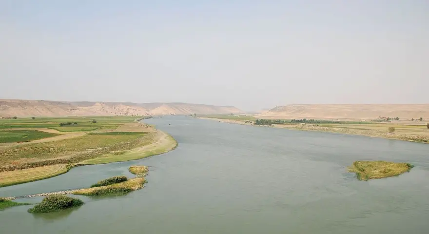 El río Éufrates serpentea entre fértiles campos verdes y áridas colinas.
