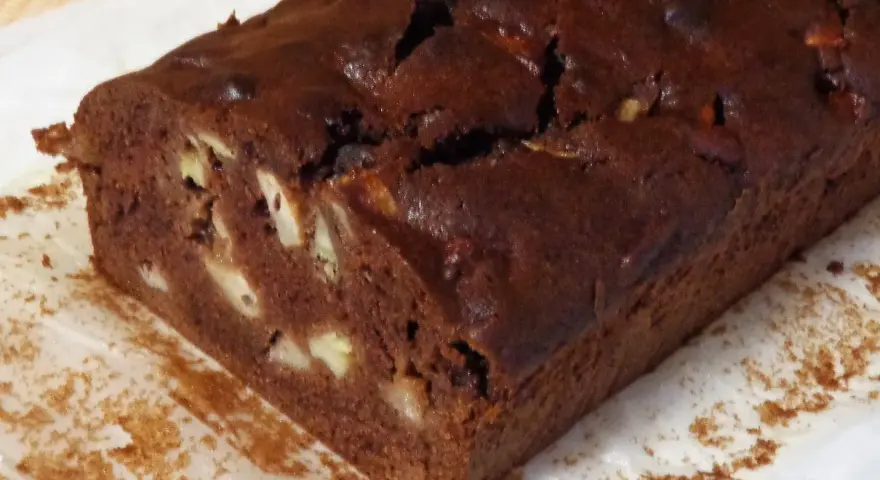 Wilgotne ciasto czekoladowe z bananami, z widocznymi kawałkami owoców w środku.