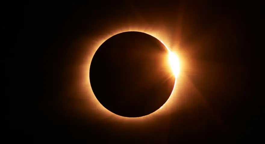 Eclipse solar total, con el sol brillando intensamente alrededor del disco lunar. El **nodo norte y nodo sur** celestes se alinean para este espectáculo.