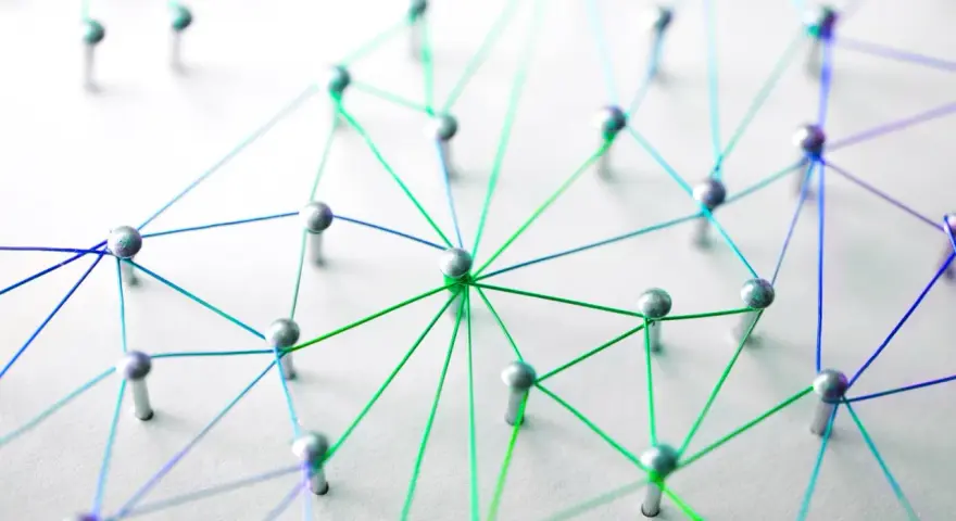 Netzwerk aus silbernen Pins und bunten Fäden auf weißem Untergrund.
