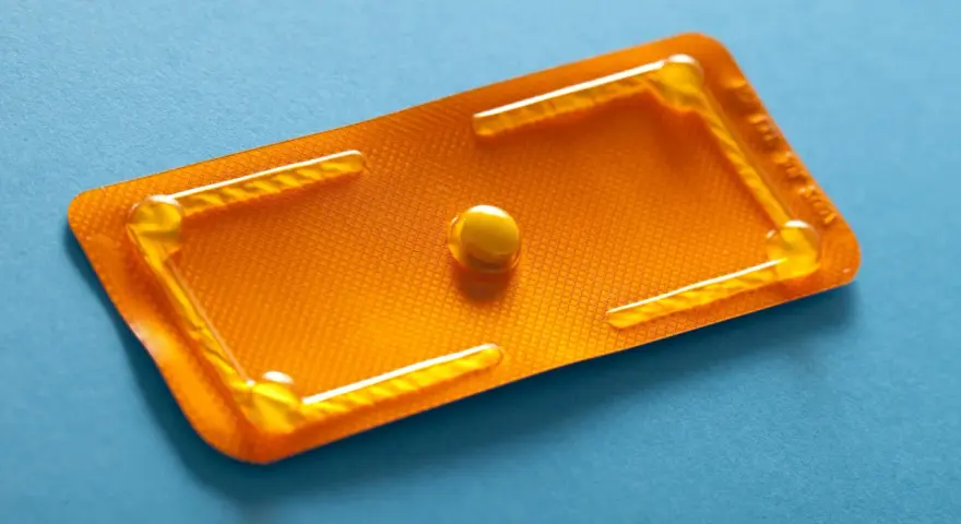 Pillola del giorno dopo, confezione arancione con una singola pillola. Un promemoria visivo di scelte importanti.