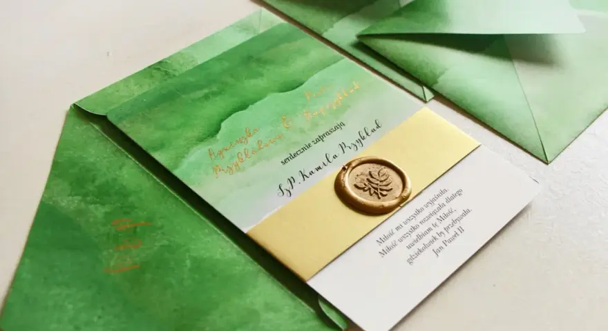 Zielone zaproszenia z akwarelowymi wzorami i złotym lakowym stemplem. Czy warto inwestować w personalizowaną papeterię rzemieślniczą z lakiem? Tak!
