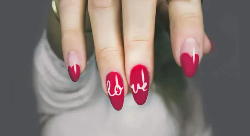 Unghie gel rosse con cuore e scritta "love". Perfetti disegni unghie gel facili per San Valentino.
