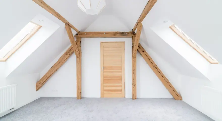 Drewniane belki na poddaszu, idealne do pomalowania na biało lub pozostawienia w naturalnym kolorze.