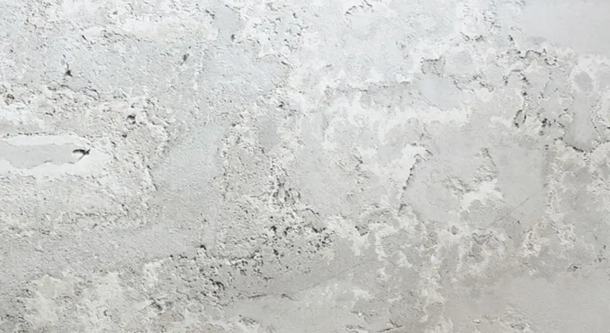 Textura de pared con manchas blancas y grises, como si la pintura se estuviera descascarando.