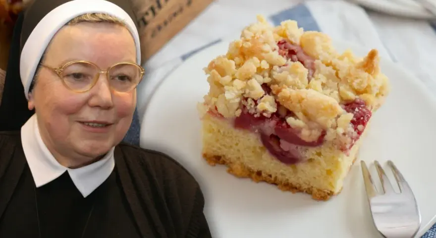 Siostra z uśmiechem prezentuje wilgotne ciasto ucierane ze śliwkami, posypane kruszonką.