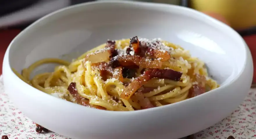 Spaghetti cremosi con guanciale croccante e pecorino, un'autentica ricetta della carbonara.