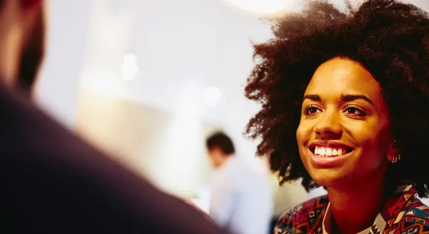 Donna sorridente in un colloquio, pensando a che lavoro fare a 40 anni senza esperienza.