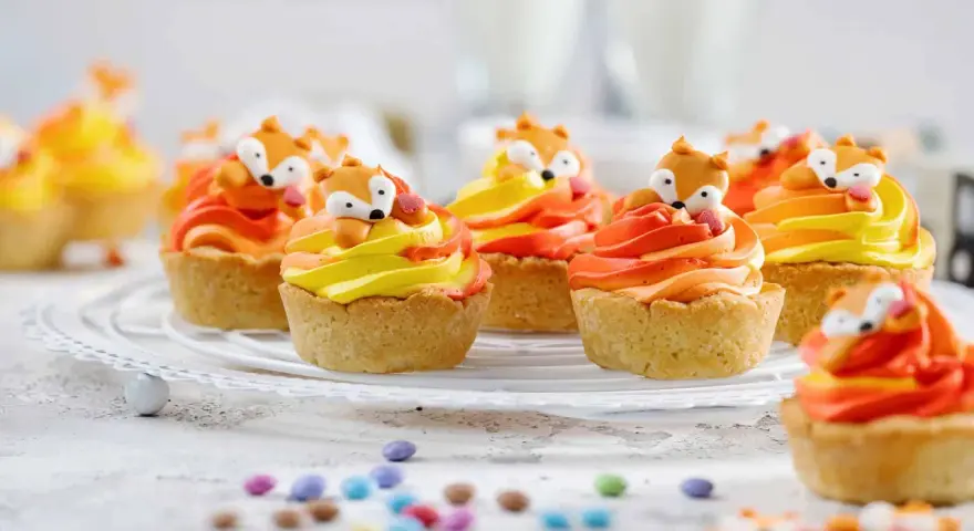 Niedliche Fuchstörtchen mit orange-gelber Creme, perfekt als Geburtstagskuchen für Kinder.