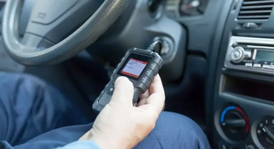 Diagnostyka Opla z kodem DTC U0415. Mechanik sprawdza błędy w samochodzie za pomocą czytnika OBD.