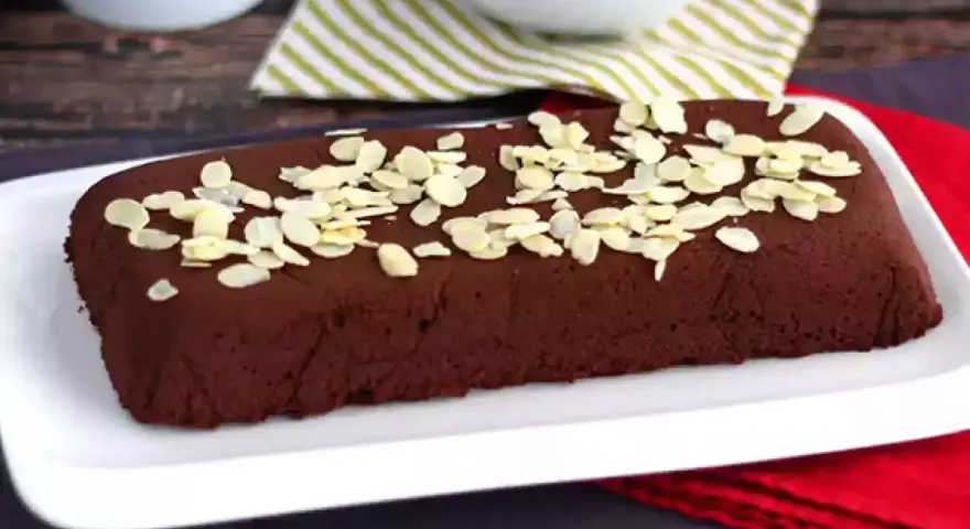Une délicieuse marquise au chocolat, parsemée d'amandes effilées, attend d'être dégustée.
