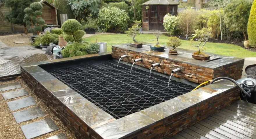 Estanque con cascadas y bonsáis, ideal para recoger agua de lluvia. Un oasis zen en el jardín.