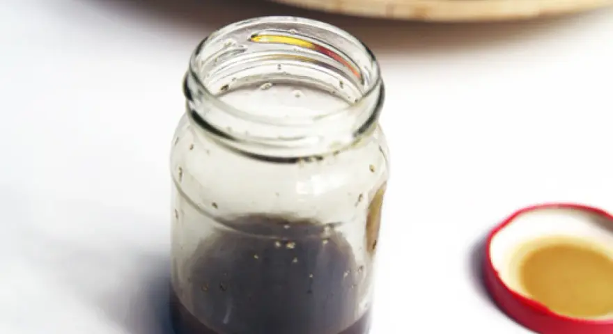Słoik z domowym sosem balsamicznym i otwartą czerwoną zakrętką.