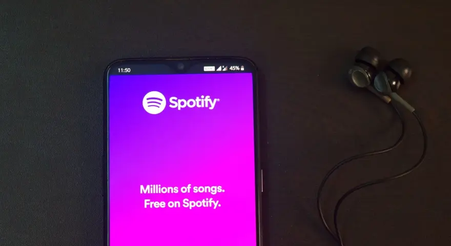 Telefon z aplikacją Spotify i słuchawkami. Idealne do słuchania wzruszających piosenek o przyjaźni.