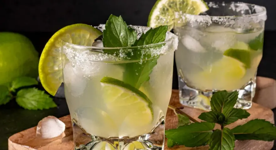 Orzeźwiające mojito z limonką i miętą, idealne na upalne dni. Lód, cukier i świeże składniki tworzą idealną kompozycję.