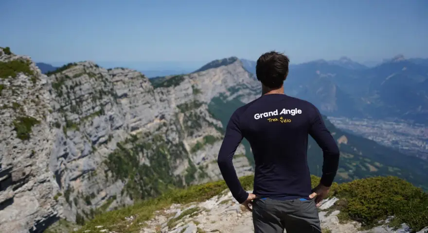 Un cycliste admire le panorama après un **tour du Vercors 7 jours**. Le paysage montagneux est spectaculaire.