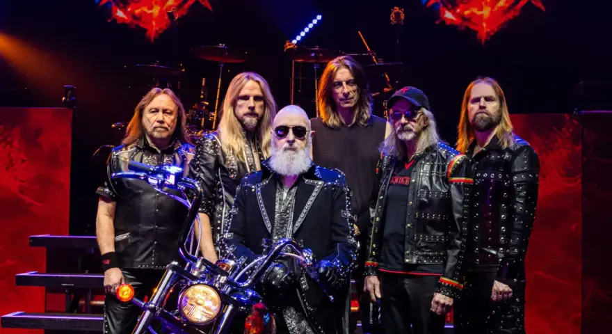 Judas Priest Polska: zespół w skórzanych kurtkach z ćwiekami, z motocyklem na scenie.