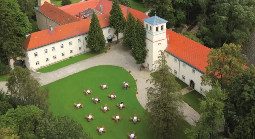 Trzebieszowice zamek na skale, otoczony zielenią, z dziedzińcem i ogródkiem kawowym.