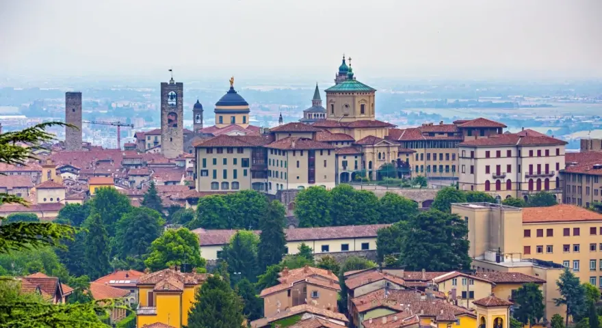 Panorama Bergamo, gdzie zwiedzić warto zabytkowe wieże i kopuły. Miasto zachwyca architekturą i zielenią.