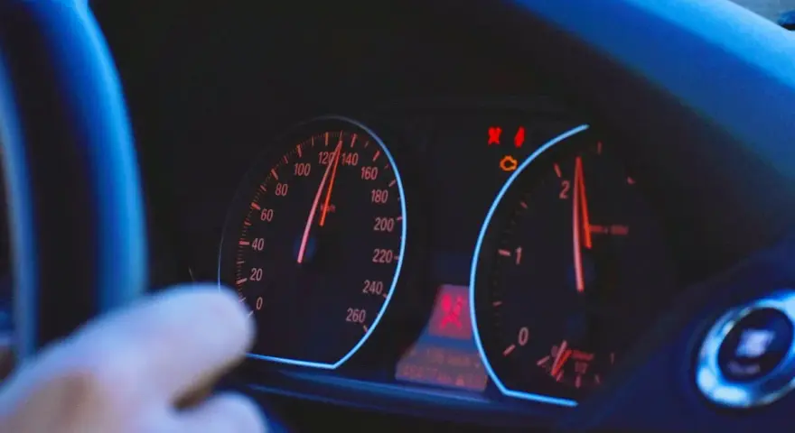 Blick auf das Armaturenbrett eines Autos. Der Tacho zeigt 120 km/h, die Drehzahl ist bei 2000 U/min. Die Tacho-Toleranz ist hierbei zu beachten.