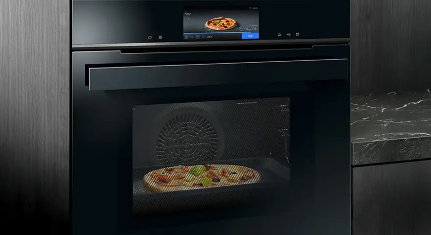 Modern ugn med touchskärm som visar en pizza. Denna Siemens studioline ugn har ångfunktion för perfekt bakning.