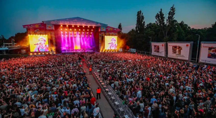 Koncert na Orange Warsaw Festival z tłumem widzów i artystą na telebimie.