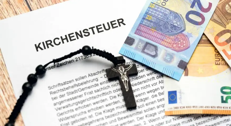Kirchensteuer-Dokument mit Kreuz und Euro-Scheinen. Lohnt sich Kirchenaustritt finanziell? Die Dokumente und Geldscheine deuten auf eine finanzielle Entscheidung hin.