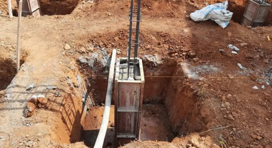 Wykop pod fundament słupowy, zbrojenie i szalunek gotowe do zalania betonem.
