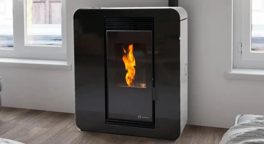 Caldera mixta leña y pellets con llama encendida, diseño moderno en negro y blanco, junto a una ventana.