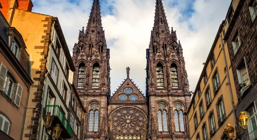 La cathédrale de Clermont-Ferrand, une des plus belles cathédrales de France, se dresse fièrement entre des immeubles anciens.