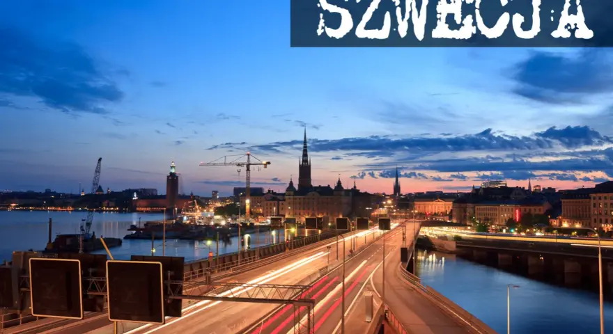 Widok na nocny Sztokholm, gdzie widać most z rozmazanymi światłami samochodów, rzekę i zabytkowe budynki. Tak wygląda Szwecja.
