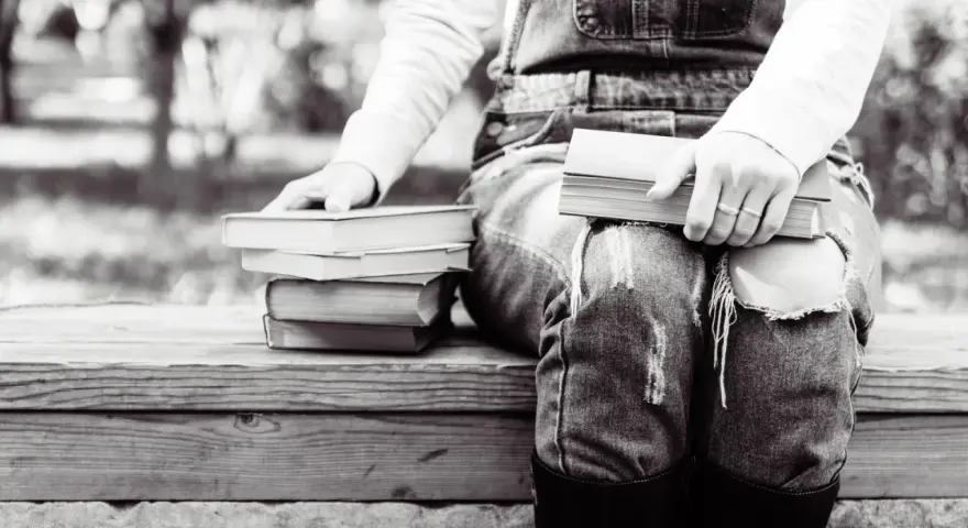 Persona sentada con varios libros en francés fáciles de leer, listos para una tarde de lectura.