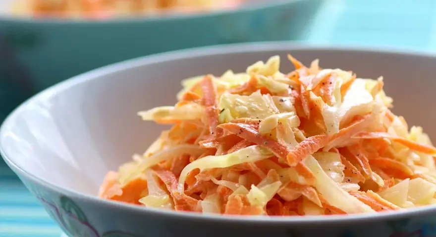 Un bol de véritable sauce coleslaw, mélange frais de chou râpé et de carottes, assaisonné de poivre noir.