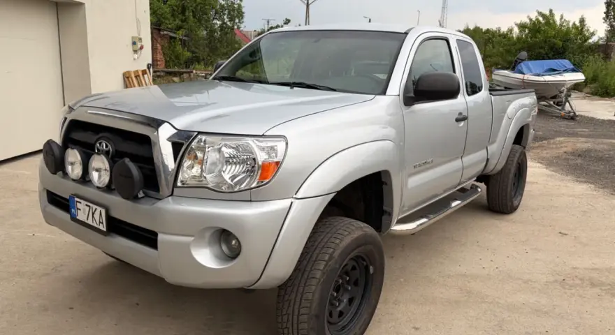 Srebrna Toyota Tacoma z dodatkowymi światłami, gotowa na przygodę.