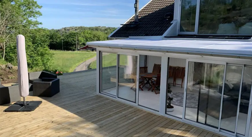 Ny slipad altan med glasveranda och utemöbler. Perfekt för att njuta av sommaren.