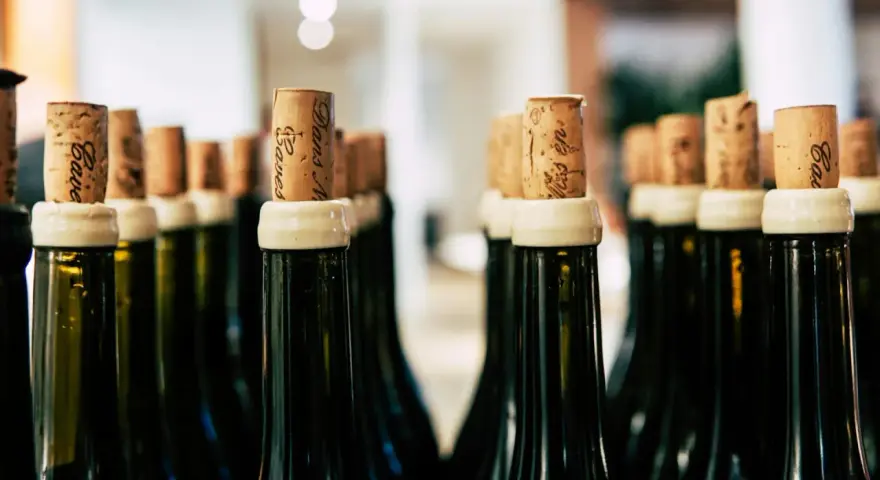 Rzędy butelek z korkami, gotowe na degustację. Każdy korek to obietnica smaku, jak wino wytrawne po włosku.