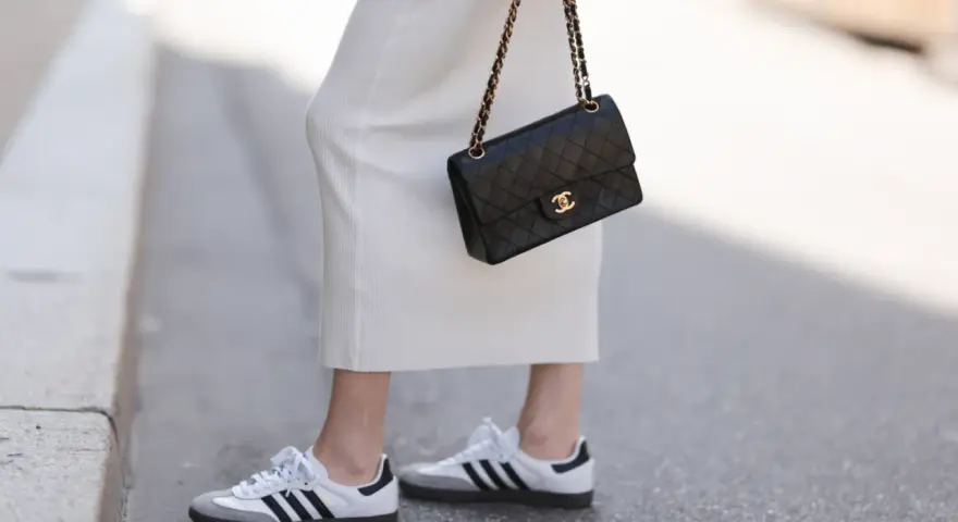 Biała sukienka, czarna torebka Chanel i najmodniejsze adidasy damskie – idealny zestaw na miejski spacer.