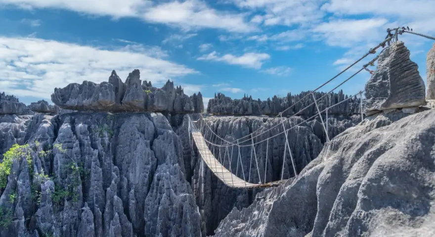 Most skalnych iglic Tsingy de Bemaraha, z wiszącym mostem nad przepaścią.