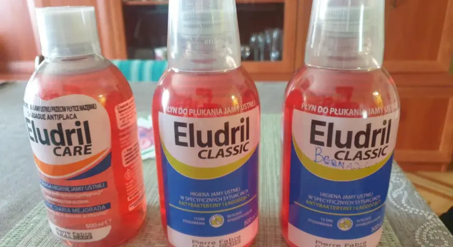Trzy butelki płynu do płukania jamy ustnej Eludril: wersja Care, Classic i Classic z dopiskiem. Różne rodzaje Eludril do higieny jamy ustnej.