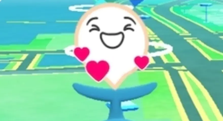 Szczęśliwy pokemon go buddy, otoczony serduszkami, wesoło macha ogonem na tle mapy gry.